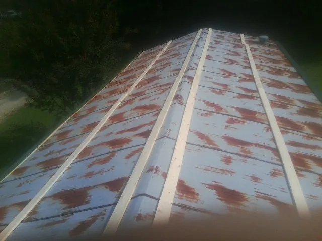 Rusted metal roof panels with new wood purlins before replacement — Storm Damage Roof Repair in Spring Gap by Roofing Brothers